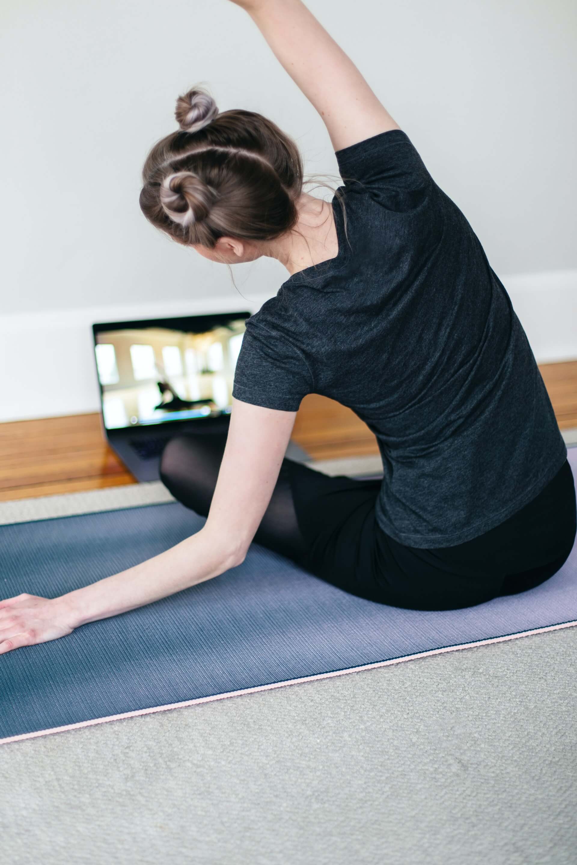 Person attending a yoga session on their laptop